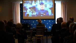 Sala pełna ludzi, na telebimie policjantka.